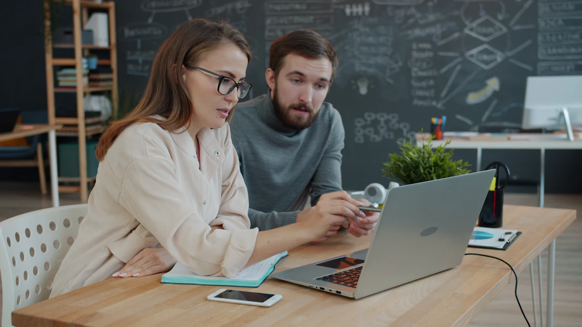 Dua orang menatap satu layar laptop yang sama sambil berdiskusi