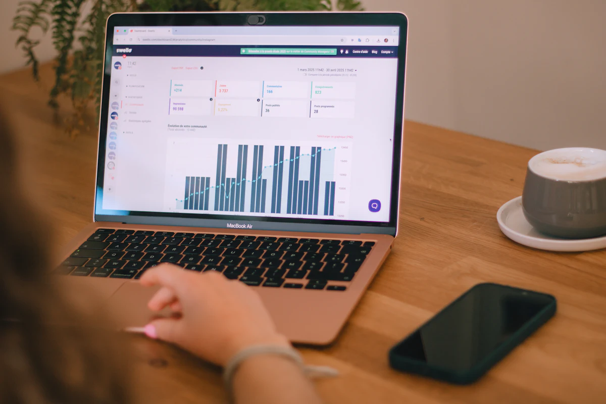 Seseorang membaca grafik laporan di layar laptop di atas meja