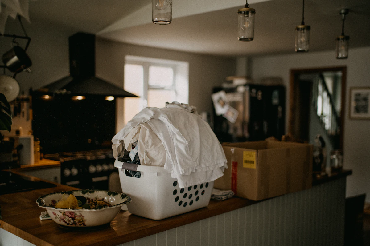 Keranjang cucian berisi pakaian diletakkan di atas konter kayu tempat penerimaan laundry