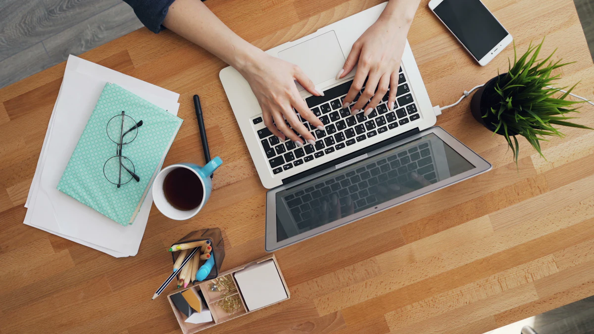 Seseorang mengetik di laptop yang terbuka di atas meja kayu