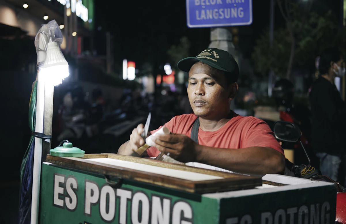 Seorang pedagang menulis catatan tangan di atas kertas di meja kerjanya