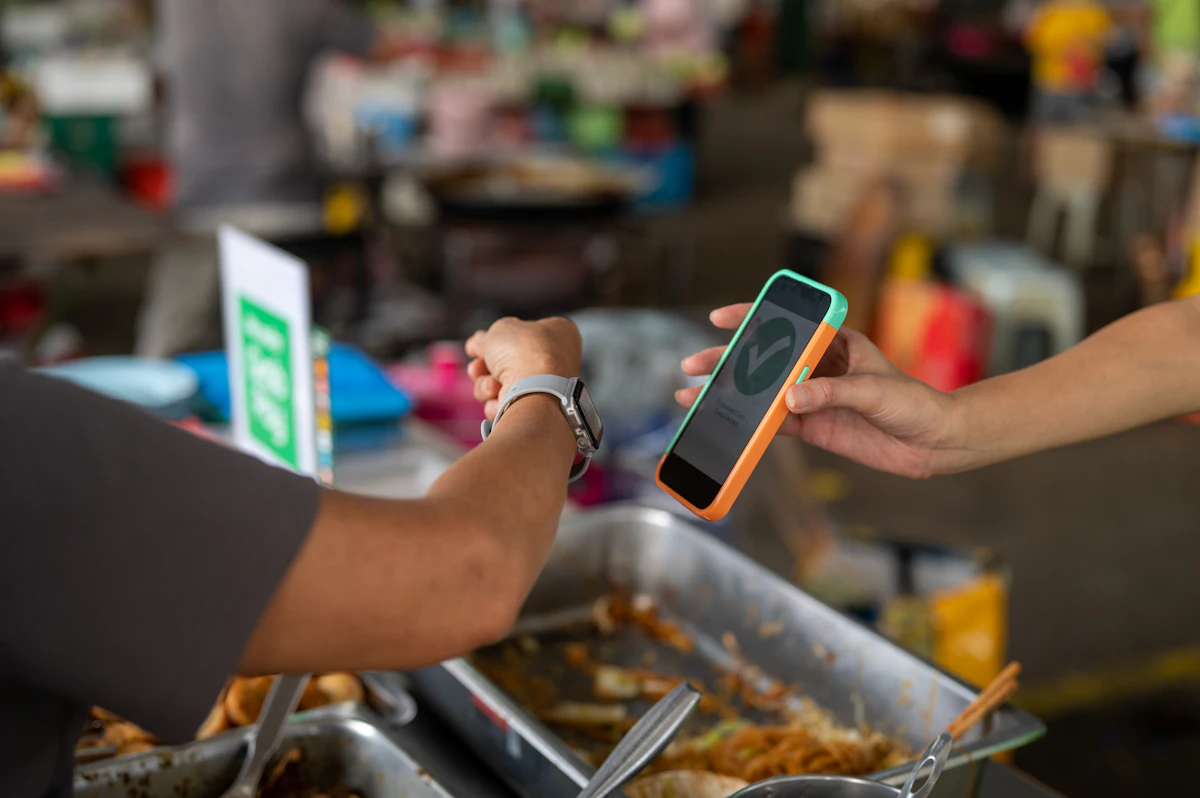 Satu orang menyerahkan ponsel ke tangan orang lain